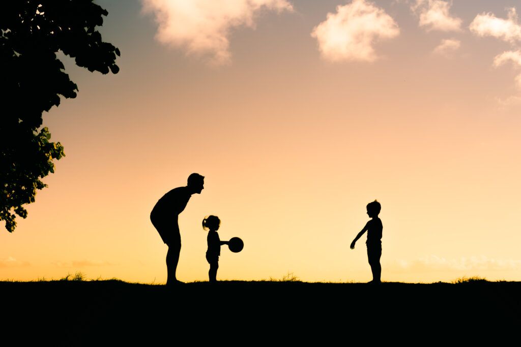 Foster parent and children playing in a park